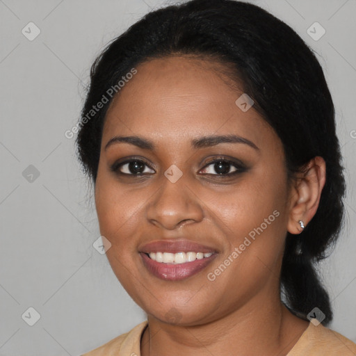 Joyful black young-adult female with long  black hair and brown eyes