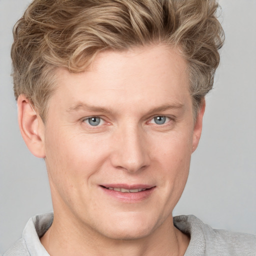 Joyful white young-adult male with short  brown hair and blue eyes