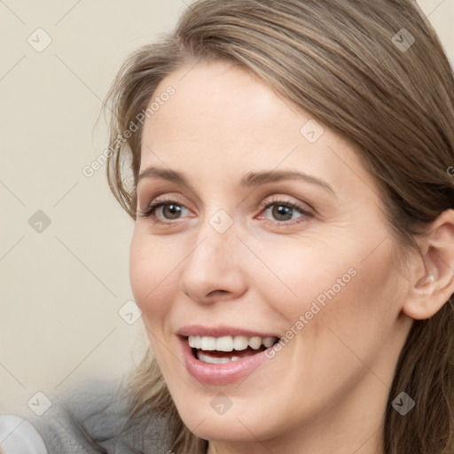 Joyful white young-adult female with long  brown hair and grey eyes