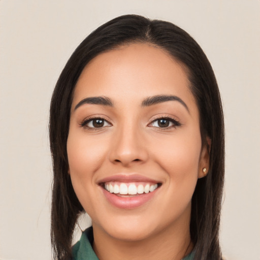 Joyful latino young-adult female with long  brown hair and brown eyes