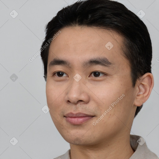 Joyful asian young-adult male with short  black hair and brown eyes