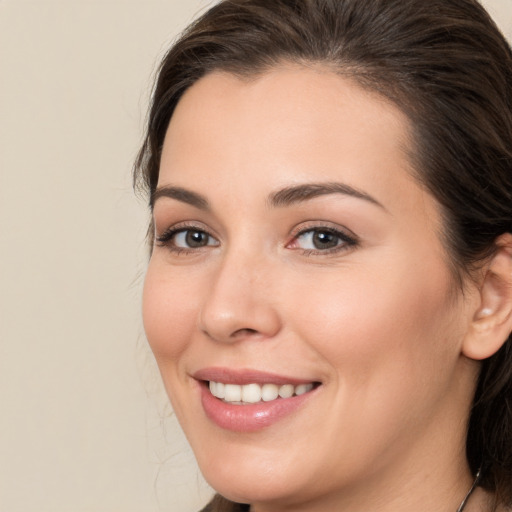 Joyful white young-adult female with long  brown hair and brown eyes