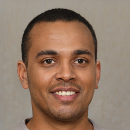 Joyful latino young-adult male with short  brown hair and brown eyes