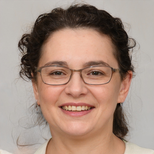 Joyful white adult female with medium  brown hair and blue eyes