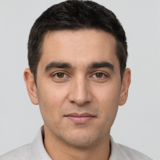 Joyful white young-adult male with short  black hair and brown eyes