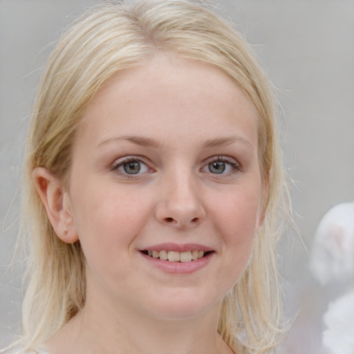 Joyful white young-adult female with medium  blond hair and blue eyes