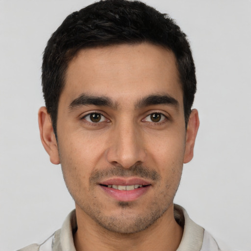 Joyful white young-adult male with short  black hair and brown eyes
