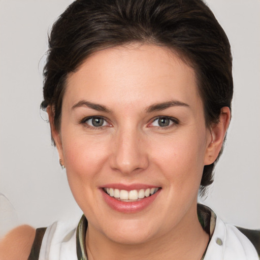 Joyful white young-adult female with medium  brown hair and green eyes