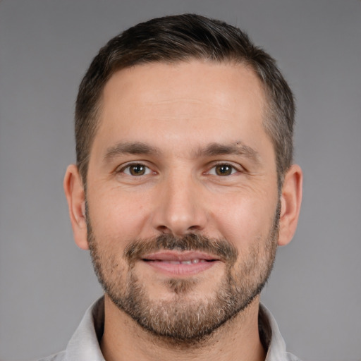 Joyful white adult male with short  brown hair and brown eyes