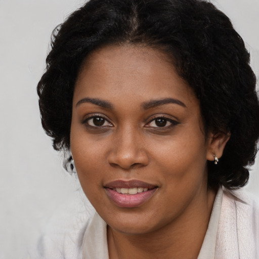 Joyful black young-adult female with long  black hair and brown eyes