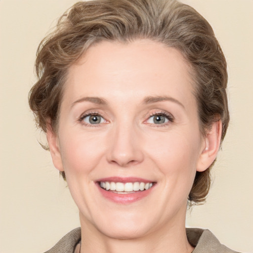 Joyful white adult female with medium  brown hair and grey eyes