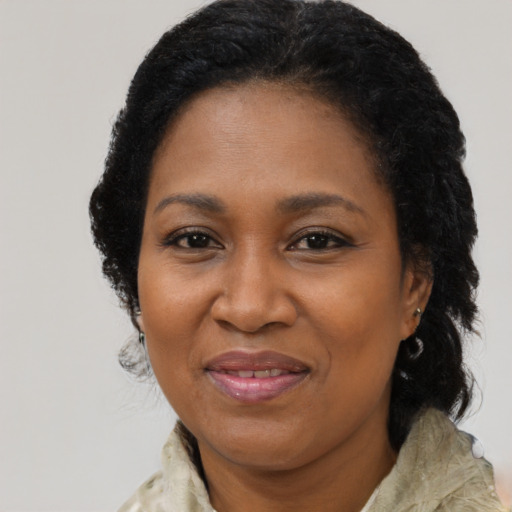 Joyful black adult female with long  brown hair and brown eyes