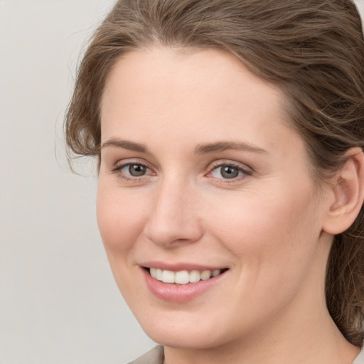 Joyful white young-adult female with medium  brown hair and grey eyes