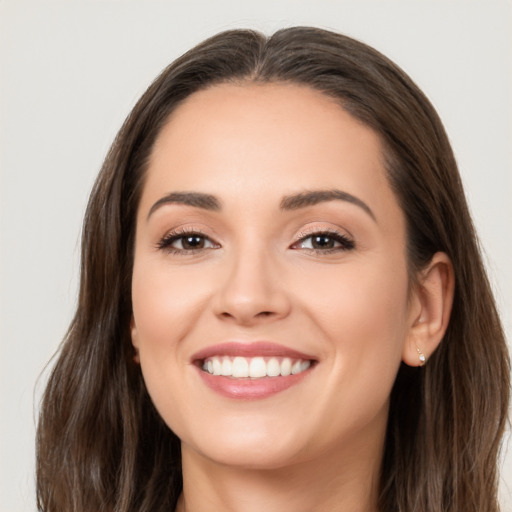 Joyful white young-adult female with long  brown hair and brown eyes