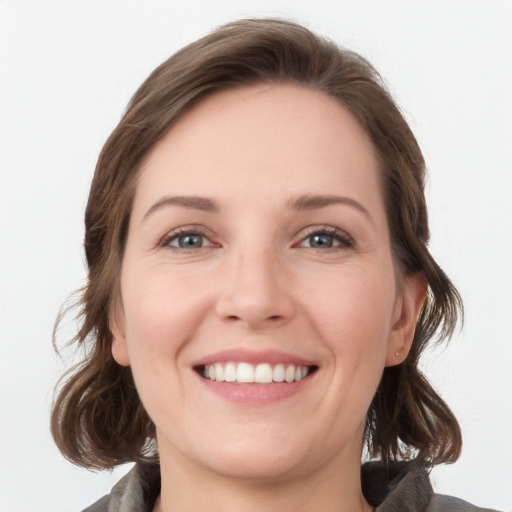 Joyful white young-adult female with medium  brown hair and grey eyes