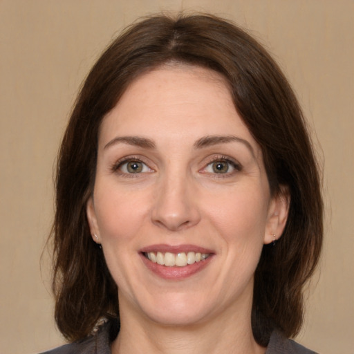 Joyful white adult female with medium  brown hair and brown eyes