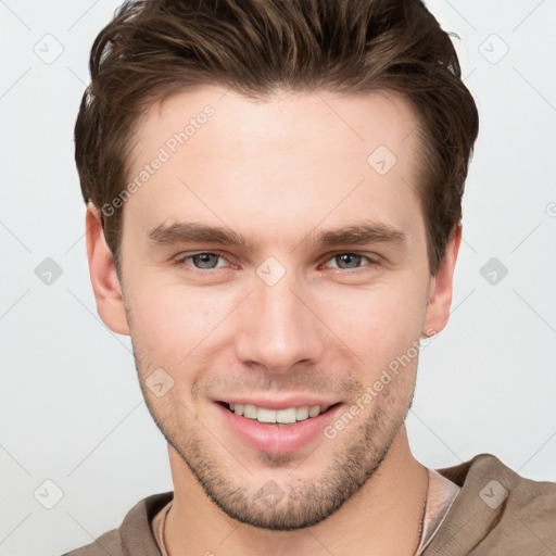 Joyful white young-adult male with short  brown hair and grey eyes