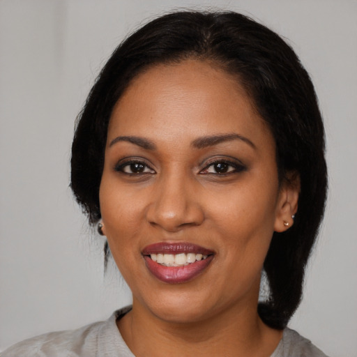 Joyful black young-adult female with medium  black hair and brown eyes