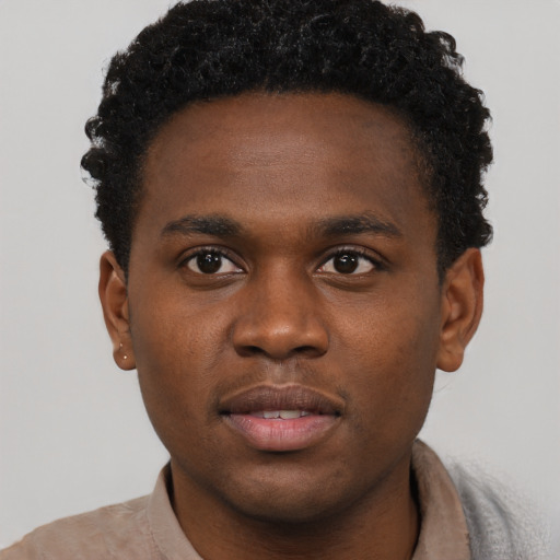 Joyful black young-adult male with short  brown hair and brown eyes