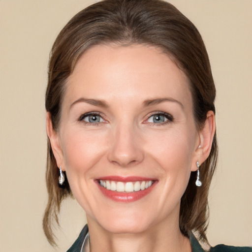 Joyful white adult female with medium  brown hair and grey eyes