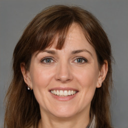 Joyful white adult female with medium  brown hair and grey eyes