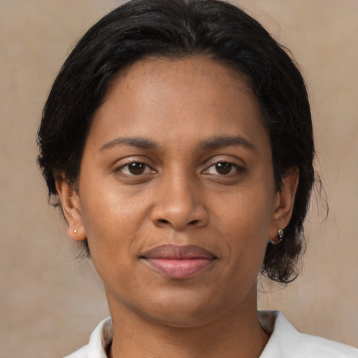 Joyful black adult female with medium  brown hair and brown eyes