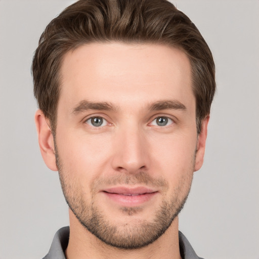 Joyful white young-adult male with short  brown hair and grey eyes