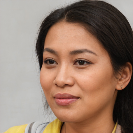 Joyful asian young-adult female with long  brown hair and brown eyes
