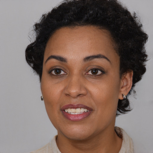 Joyful black young-adult female with short  brown hair and brown eyes