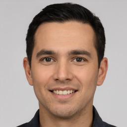 Joyful white young-adult male with short  black hair and brown eyes