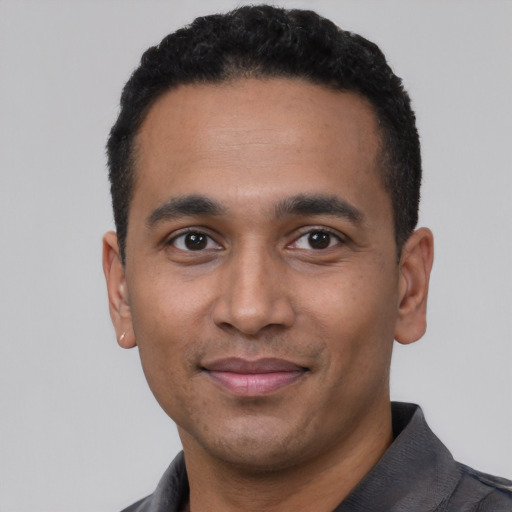 Joyful latino young-adult male with short  black hair and brown eyes