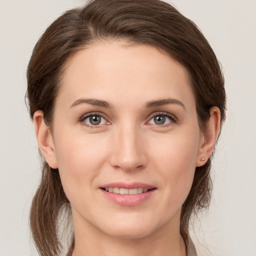 Joyful white young-adult female with medium  brown hair and grey eyes