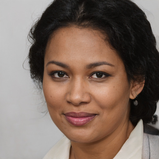 Joyful black adult female with medium  brown hair and brown eyes