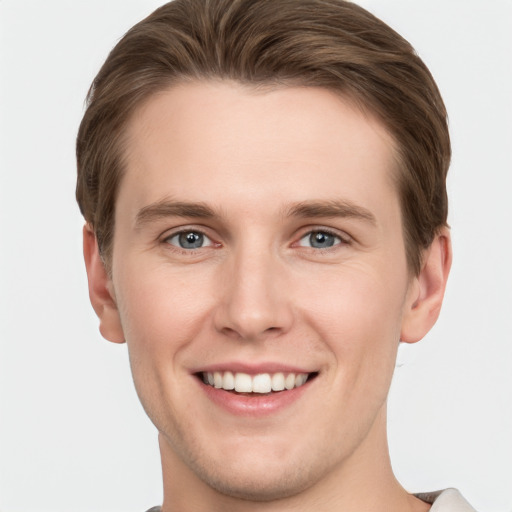 Joyful white young-adult male with short  brown hair and grey eyes