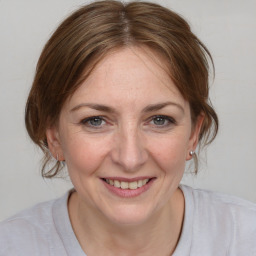 Joyful white young-adult female with medium  brown hair and blue eyes