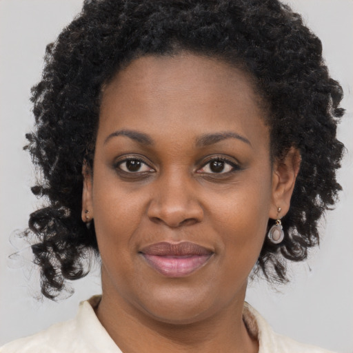 Joyful black adult female with medium  brown hair and brown eyes