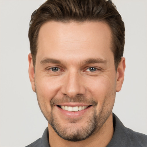 Joyful white adult male with short  brown hair and brown eyes