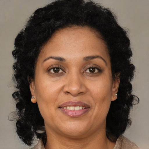 Joyful black adult female with long  brown hair and brown eyes