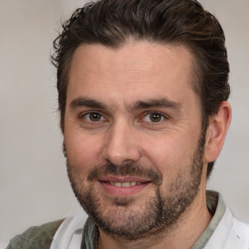 Joyful white adult male with short  brown hair and brown eyes