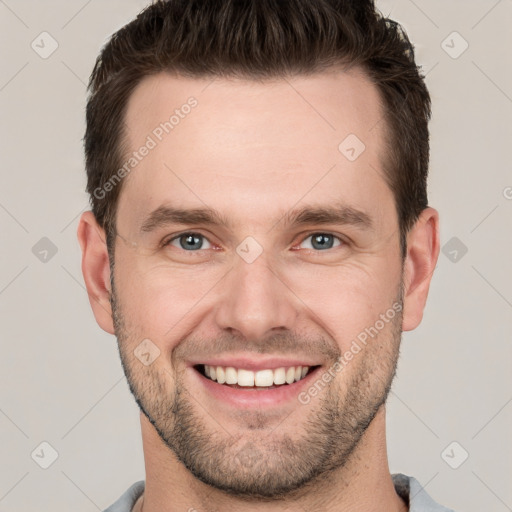 Joyful white young-adult male with short  brown hair and grey eyes