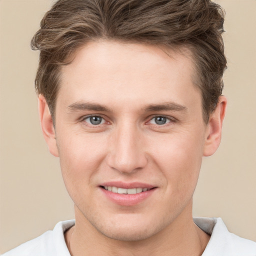 Joyful white young-adult male with short  brown hair and grey eyes