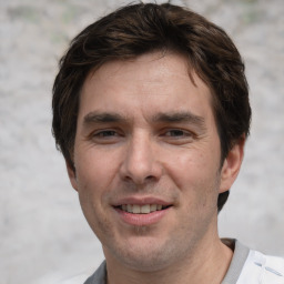 Joyful white adult male with short  brown hair and grey eyes