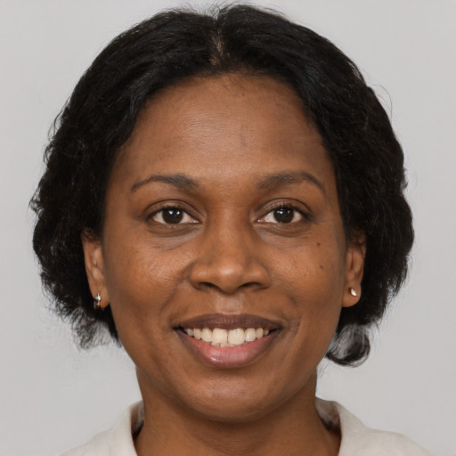Joyful black adult female with medium  brown hair and brown eyes