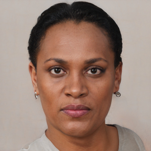 Joyful black adult female with short  black hair and brown eyes