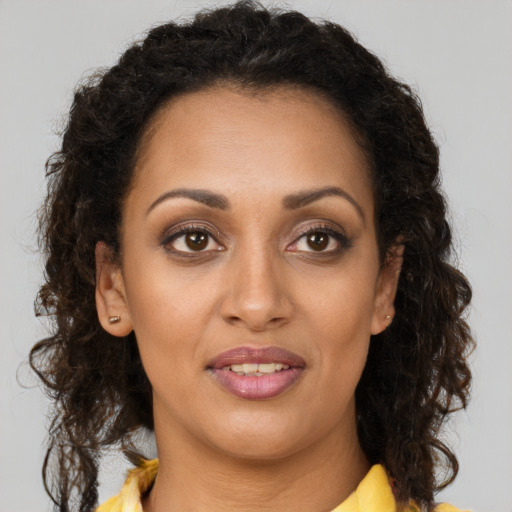 Joyful black young-adult female with long  brown hair and brown eyes