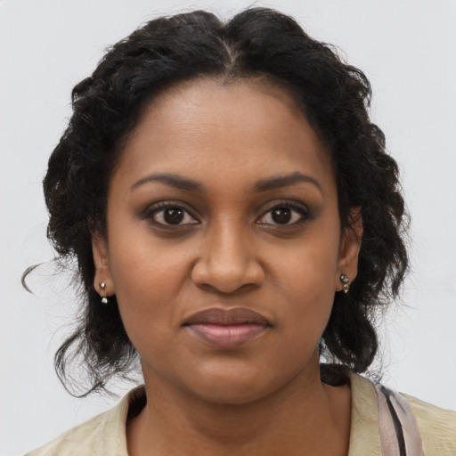 Joyful black young-adult female with long  brown hair and brown eyes