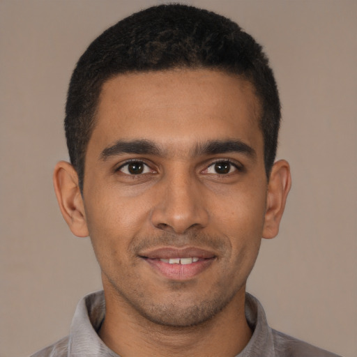 Joyful latino young-adult male with short  brown hair and brown eyes