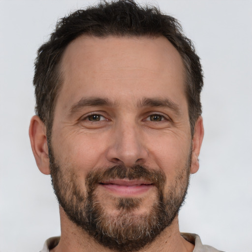 Joyful white adult male with short  brown hair and brown eyes