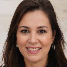 Joyful white adult female with long  brown hair and brown eyes