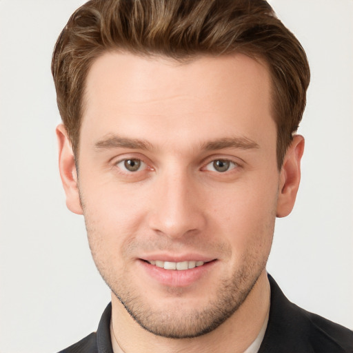 Joyful white young-adult male with short  brown hair and grey eyes